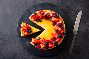 Cheesecake dessert with fresh berries. Grey background. Close up. Top view.