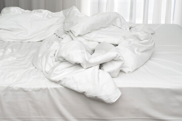 Fototapeta na wymiar Morning time in hotel, unmade bedding linen, mess with pillows, sheets, blanket