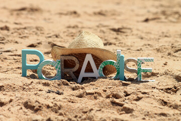 Minimalist portrait of a paradise beach with a paradise sign and a straw hat, minimalist summer background, beach and summer. 