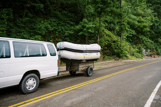 A van transports a load of white water rafts strapped to a small trailer through the Smoky Mountains.