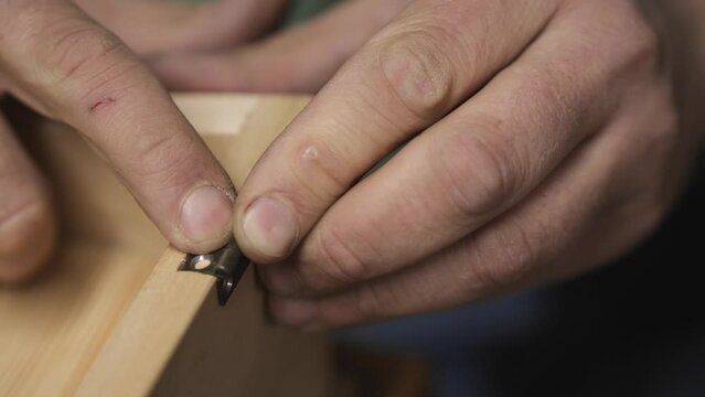 carpenter embeds a hinge in furniture