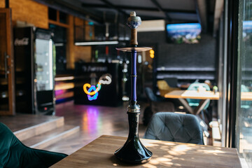 Hookah smoking at a party concept. Hookah stands on a wooden table in the interior of the...