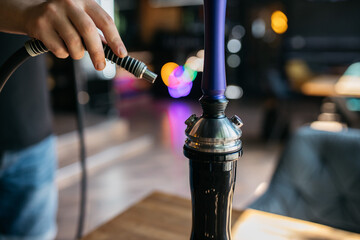 Hookah, spark, hookah sparks. Young man smokes fragrant oriental hookah. The hookah maker holds the...