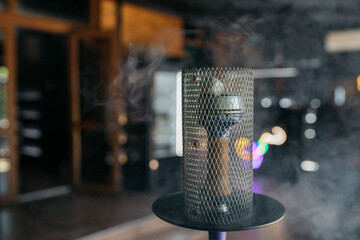 Smoking hookah at a party concept. Red hookah is standing on wooden floor in interior restaurant....