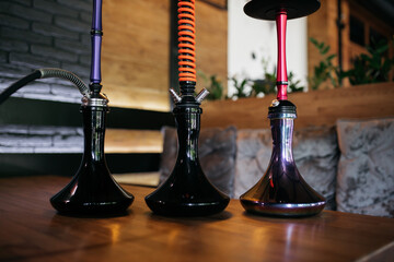 Hookah smoking at a party concept. Hookah stands on a wooden table in a restaurant. Smoking...