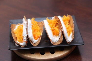 Thai Food, Thai Crispy Pancakes served in a black plate on a brown wooden table.