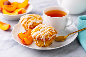 Muffins, peach fruit cupcakes with cup of tea. Marble background. Close up.