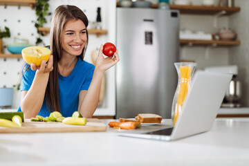 Woman reading recipes over Internet in the kitchen
