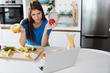  Woman reading recipes over computer in the kitchen