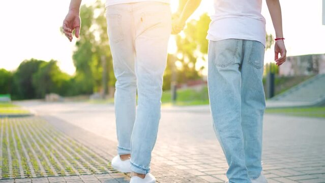 Dad and daughter walk around their area at sunset. Back view. Slow motion