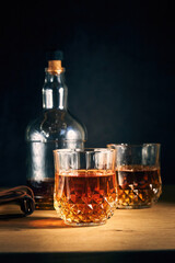 two glasses of whiskey and a bottle