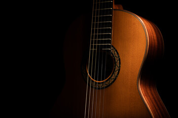 Classical guitar on a black background with copy space - obrazy, fototapety, plakaty
