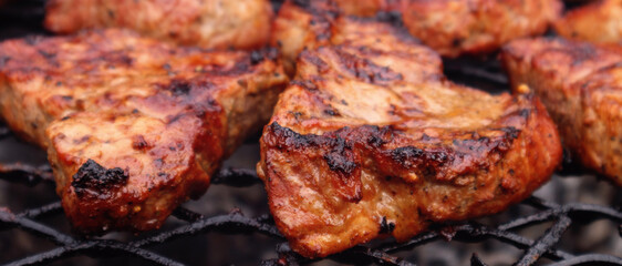Grilled pork steak close - up. Barbecue background, brown juicy meat grilled on the grill