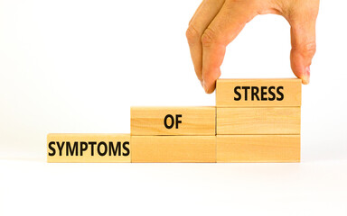 Symptoms of stress symbol. Concept words Symptoms of stress on wooden blocks. Beautiful white table white background. Doctor hand. Psychological business and Symptoms of stress concept. Copy space.