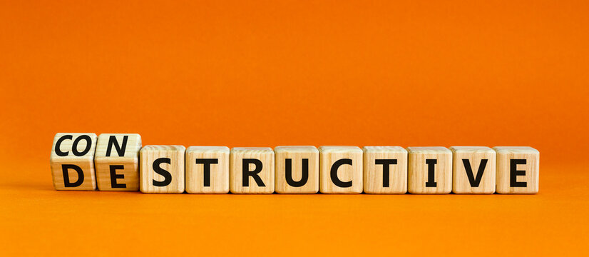 Destructive or constructive symbol. Turned wooden cubes and changed the concept word Destructive to Constructive. Beautiful orange background. Business constructive or destructive concept. Copy space.