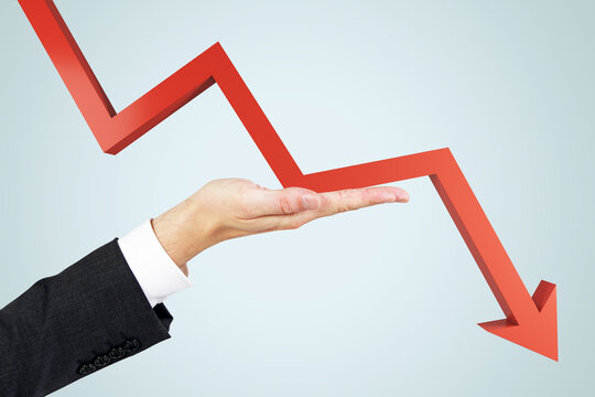 Crisis insurance concept with man hand against falling down red arrow on abstract light background