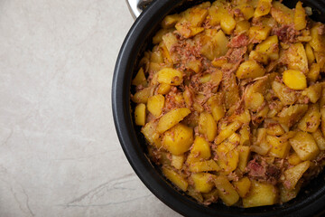 Stewed pork with potatoes and onions on a gray background.Copy space. Place for text. Recipe for fried potatoes.