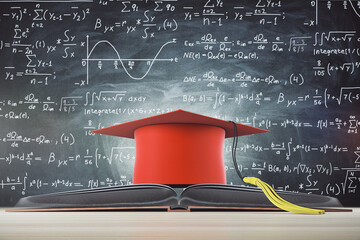 Graduation and knowledge concept with red mortarboard hat on opened book at chalkboard background...