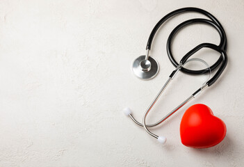 Fototapeta na wymiar Black stethoscope and red heart, on a white textural background, close-up. Healthcare. Place for text. Medicine concept. The concept of cardiology.