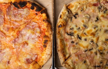Delicious hot and aromatic diabla pizza with piperoni and vegetable pizza with mushrooms. Pizza in boxes. Pizza delivery. Composition on black texture background. Copy space. Italian food. Assortment.