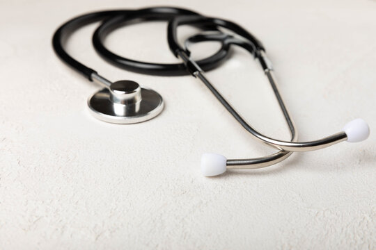 Black stethoscope on a light gray cement background. close-up. Healthcare. Place for text. medicine concept