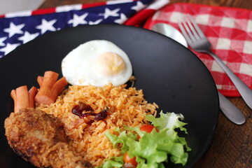 American fried rice served with sausages, cucumbers, shredded vegetables in a gray plate on a white table with seasoning.