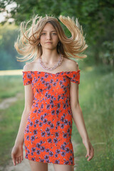 Fototapeta premium Young beautiful girl with tousled hair in the park.