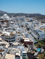 Fira, Greece - July 12 2019:   The view down into the Santorini capital of Fira overlooking the Aegean Sea from to top end of town on Agiou Ioannou