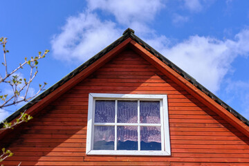 The roof of a wooden house against the blue sky, bottom view