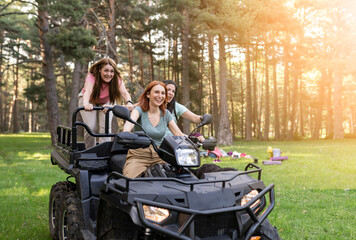 Fototapeta na wymiar group of three women on a quad bike in nature on vacation