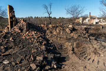Destroyed houses as a result of a fire in Russia. Bricks and parts of walls, various household items, broken windows covered with ash lie on the surface of the earth. Natural disaster
