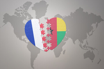 puzzle heart with the national flag of france and guinea bissau on a world map background. Concept.