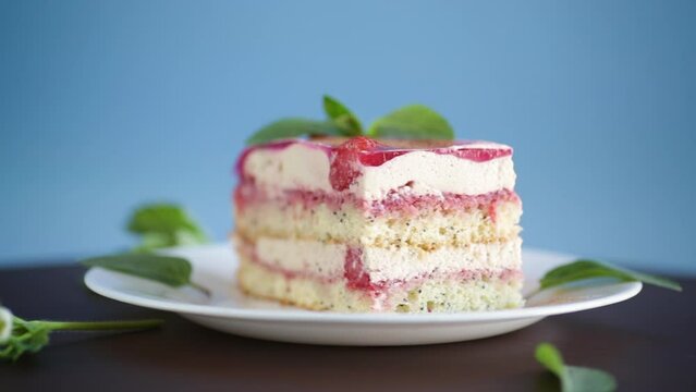 strawberry poppy cake with cream in a plate on aon a blue background