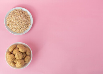 Flatlay oatmeal, oatmeal cookies on a white plate on a pink background, top view, healthy eating concept, and making cereal or cookies. A place for text on the right. High-quality photo