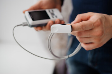 Man using finger pulse oximeter, healthcare monitoring concept. Pulse oximeter on a white background