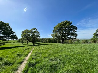 Yorkshire Dales landscape, with fields, distant hills, and a footpath, leading from the old Church in, Coniston Cold, Skipton, UK