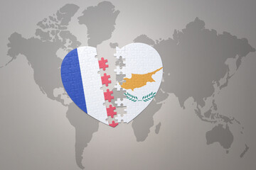 puzzle heart with the national flag of france and cyprus on a world map background. Concept.