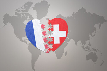 puzzle heart with the national flag of france and switzerland on a world map background. Concept.