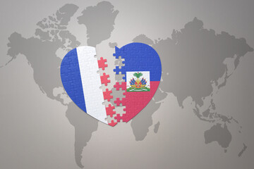Fototapeta premium puzzle heart with the national flag of france and haiti on a world map background. Concept.