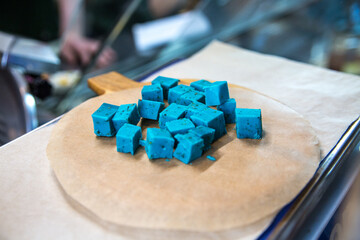 Cheese Gouda Pesto cubed on a wooden plate in a restaurant.
