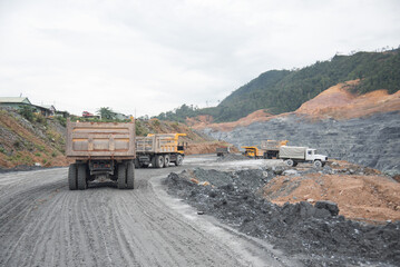 A large quarry dump truck in a coal mine. Loading coal into body work truck. Mining equipment for the transportation of minerals.