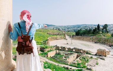 Jerash - jordan. travel tourism holiday background -young girl with hat standing pointing to...