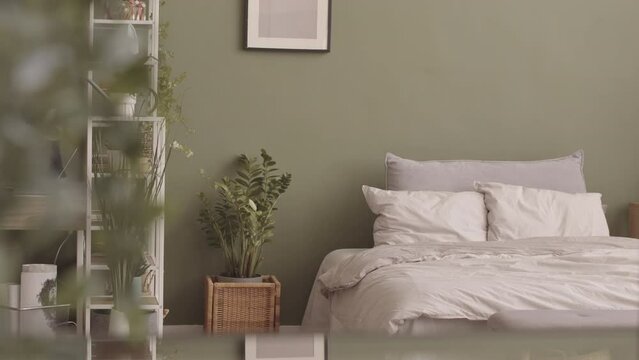 No people overview of eco style bedroom interior in natural colors with many home plants and wooden furniture
