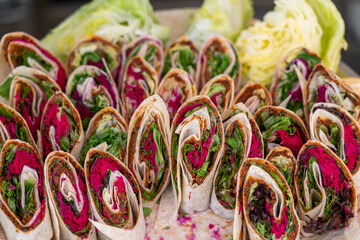 Wrap sandwich, many rolls with fresh vegetables on a plate