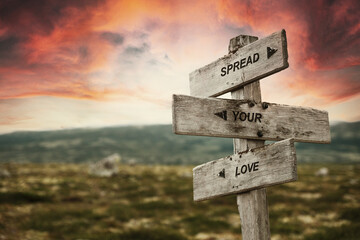 spread your love quote caption text written engraved on wooden signpost outdoors in nature with...
