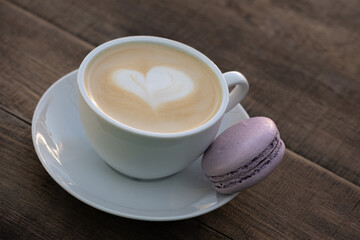 Cup of cappuccino and purple macaron