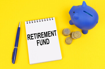 On a yellow surface, a piggy bank, coins and a notepad with the inscription - Retirement fund