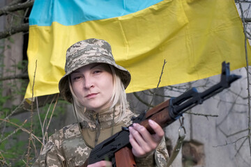 Fototapeta premium Portrait of female soldier in camouflage uniform looking at the camera