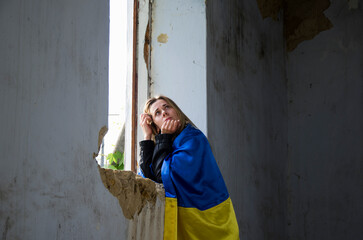 Girl praying for an end to the war. Ukrainian woman in a destroyed house. A woman prays for peace....