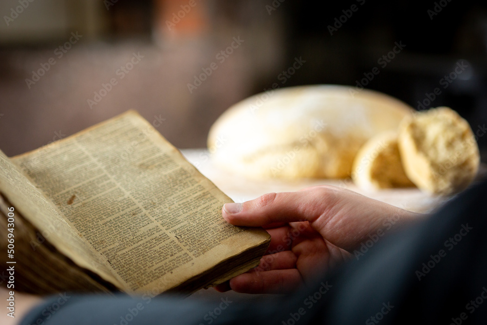 Wall mural reading the bible with bread loaf in background - Wall murals